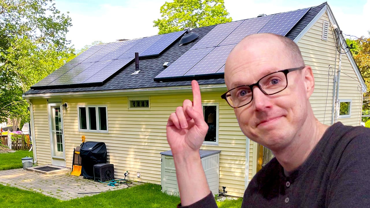 Matt Ferrell pointing at the solar panels on his roof